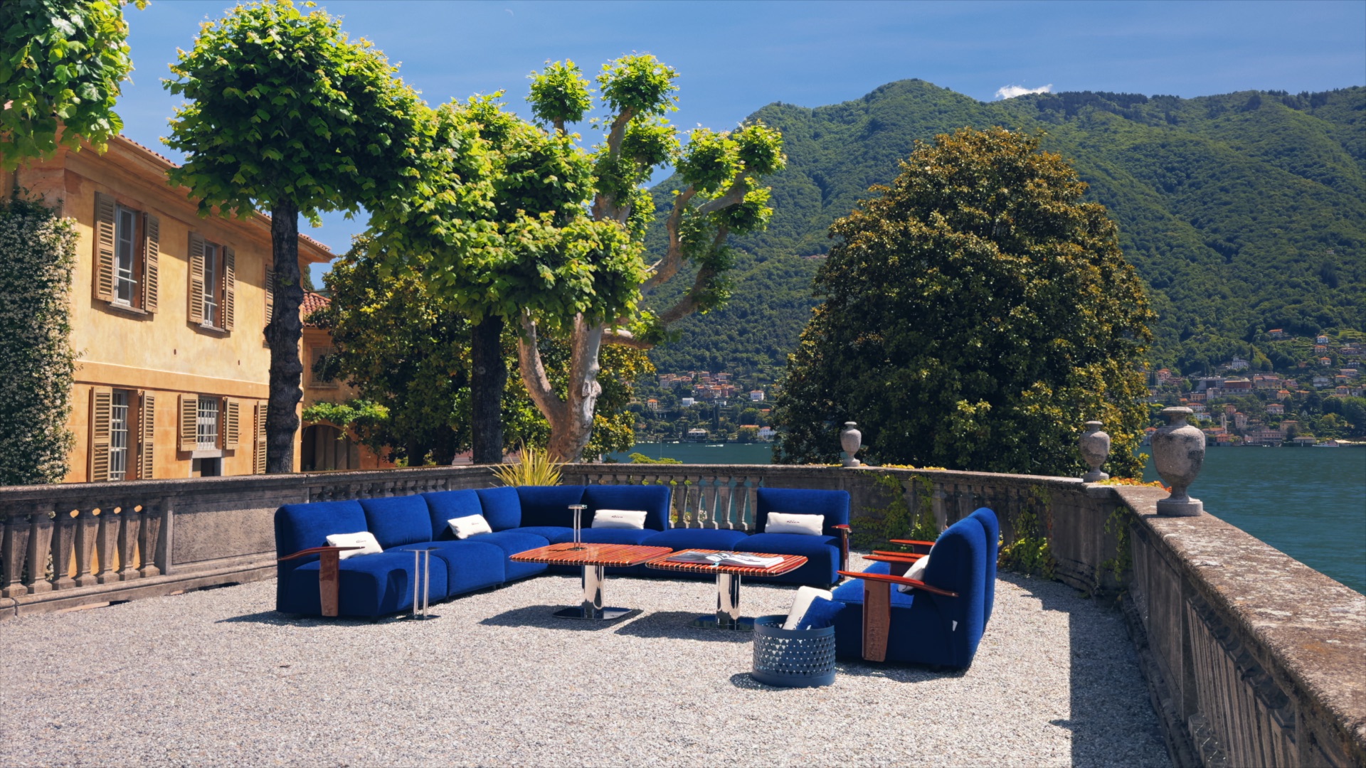 Blue sofas and armchairs from Massimo Castagna’s Exteta × Riva collection on a lakeside terrace