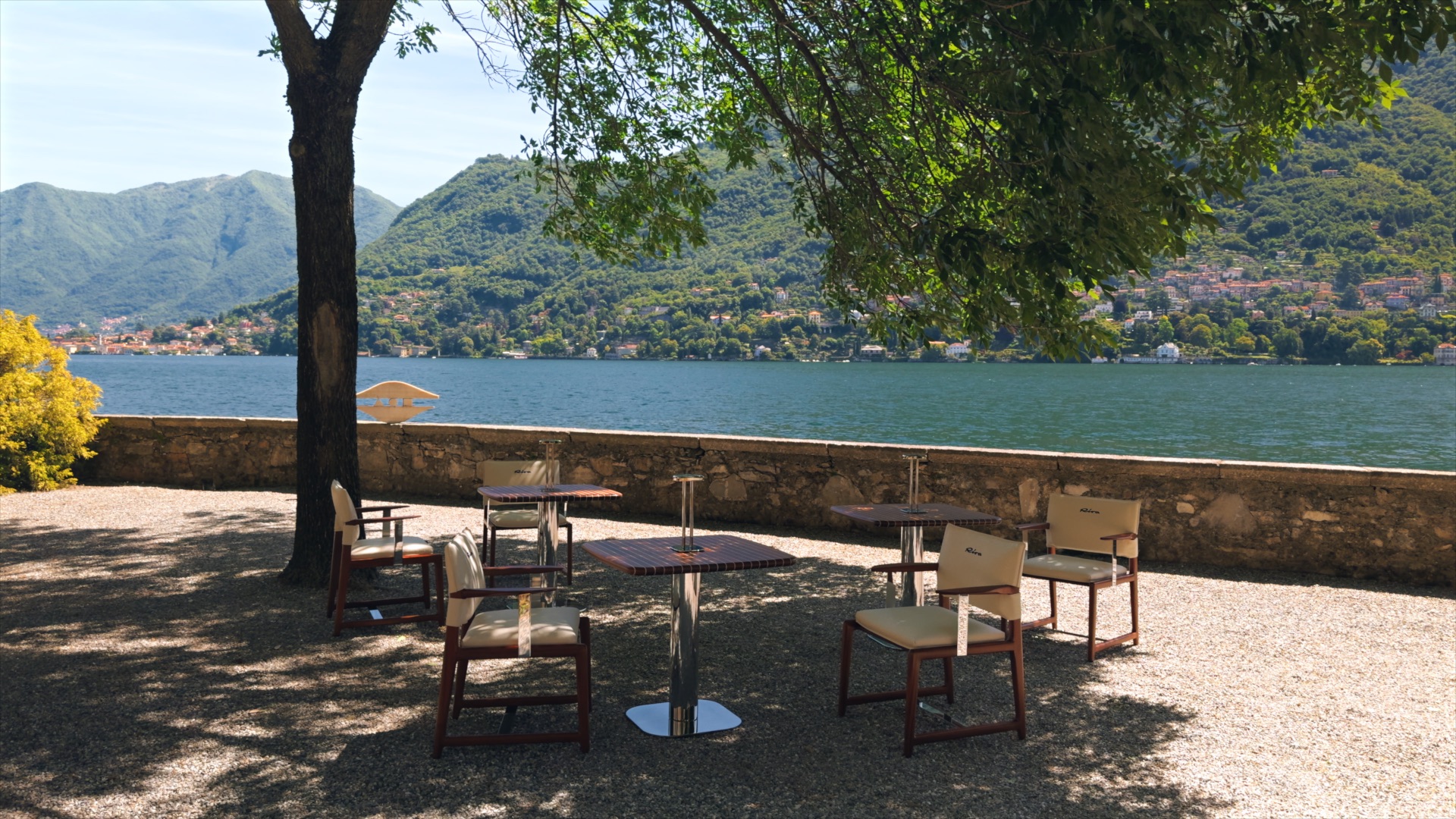 Exteta × Riva table and chairs designed by Massimo Castagna, in the shade beside the lake
